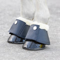 Horse feet with blue protective boots on a gray background